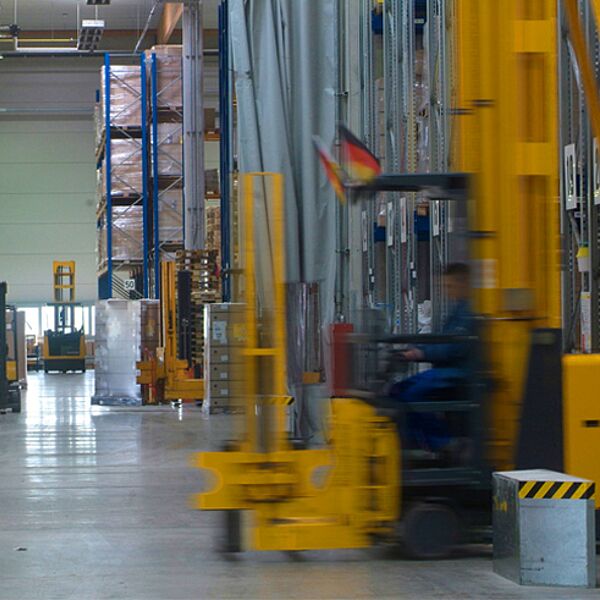 uhlhorn-kontraktlogistik-lagerhalle-gabelstapler Uhlhorn Kontraktlogistik – gelber Gabelstapler in moderner Lagerhalle, Hochregale, effiziente Lagerlogistik.