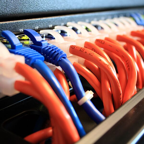uhlhorn-kontraktlogistik-netzwerkkabel Uhlhorn Kontraktlogistik – blaue und orange Netzwerkkabel im Serverschrank, IT-Infrastruktur, professionelle Verkabelung.